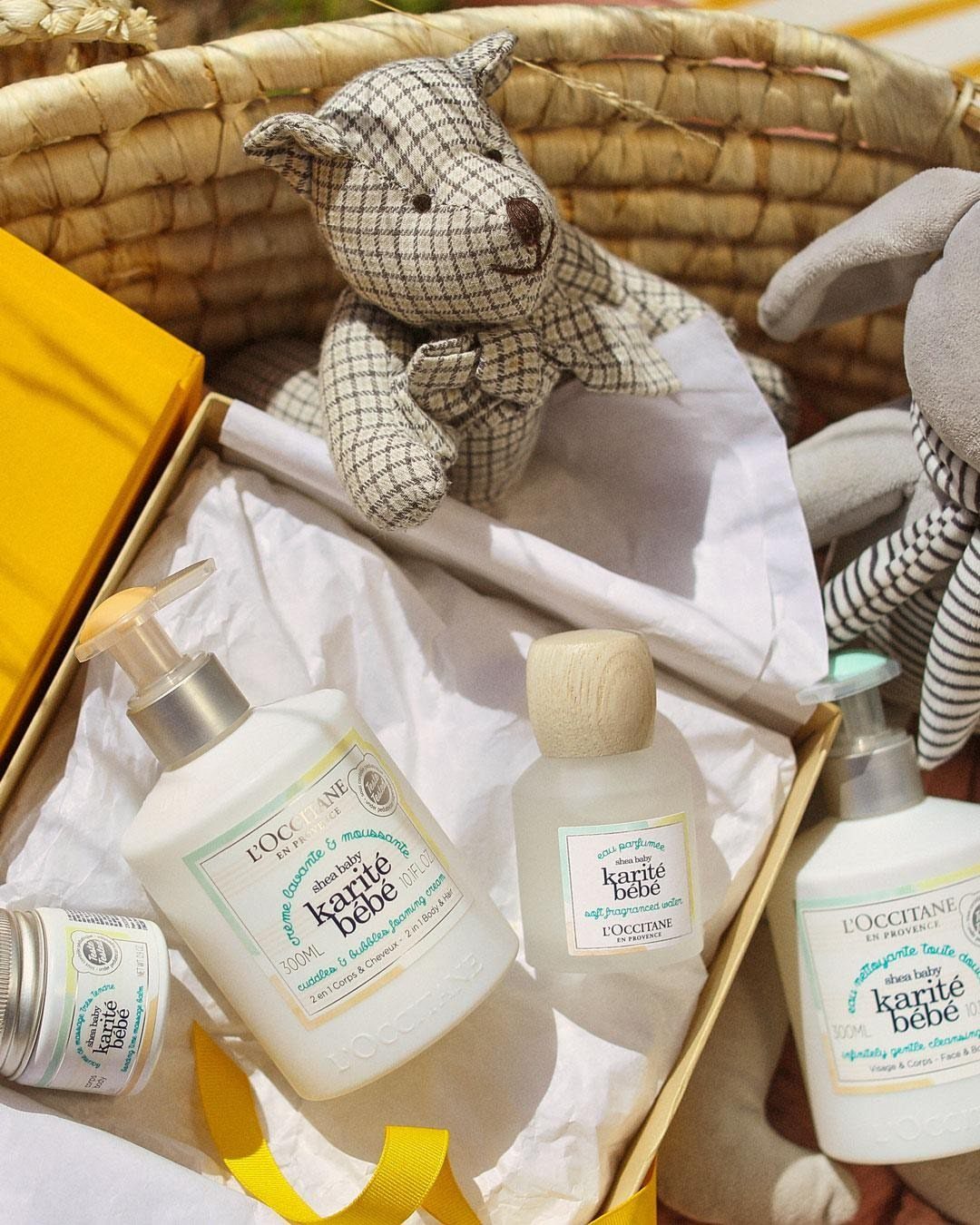 Baby bath products in a gift box with a stuffed animal in a basket