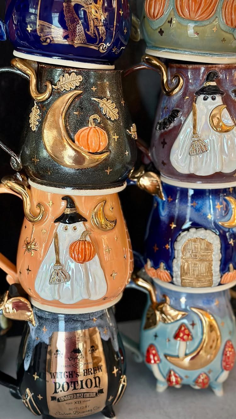 Stacked Halloween ceramic mugs featuring ghosts, pumpkins, and crescent moons with gold accents.