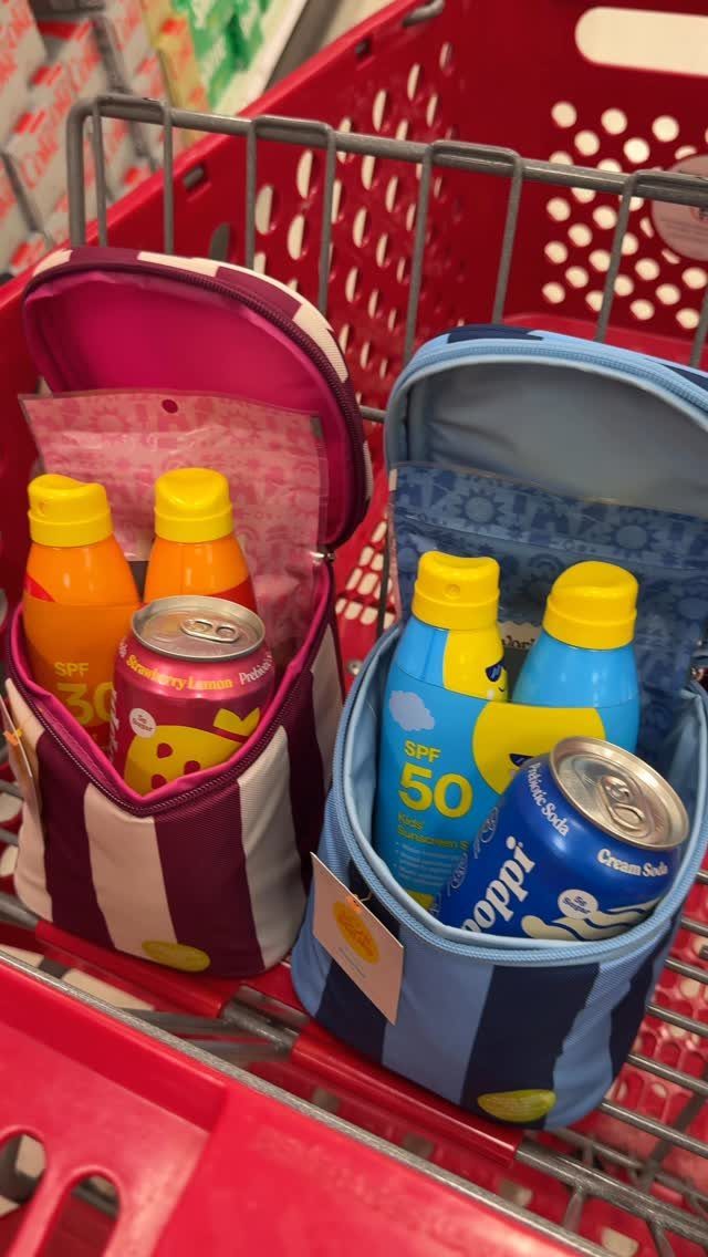 Two striped fabric gift bags filled with sunscreen and drinks in a red cart