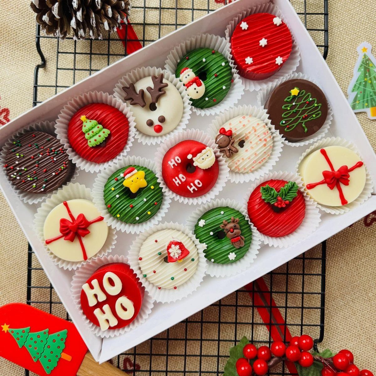 Assorted Christmas cookies in a white box with festive red and green decorations.