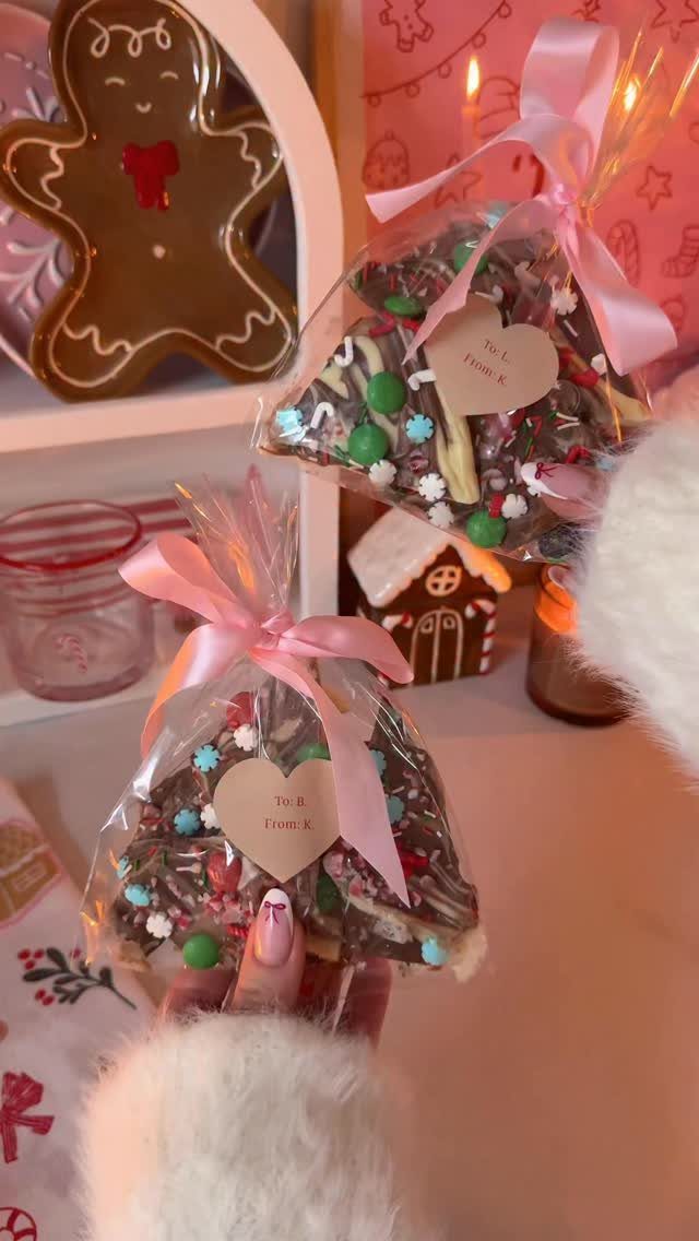 Homemade chocolate bark treats in clear bags with pink ribbons and heart tags.