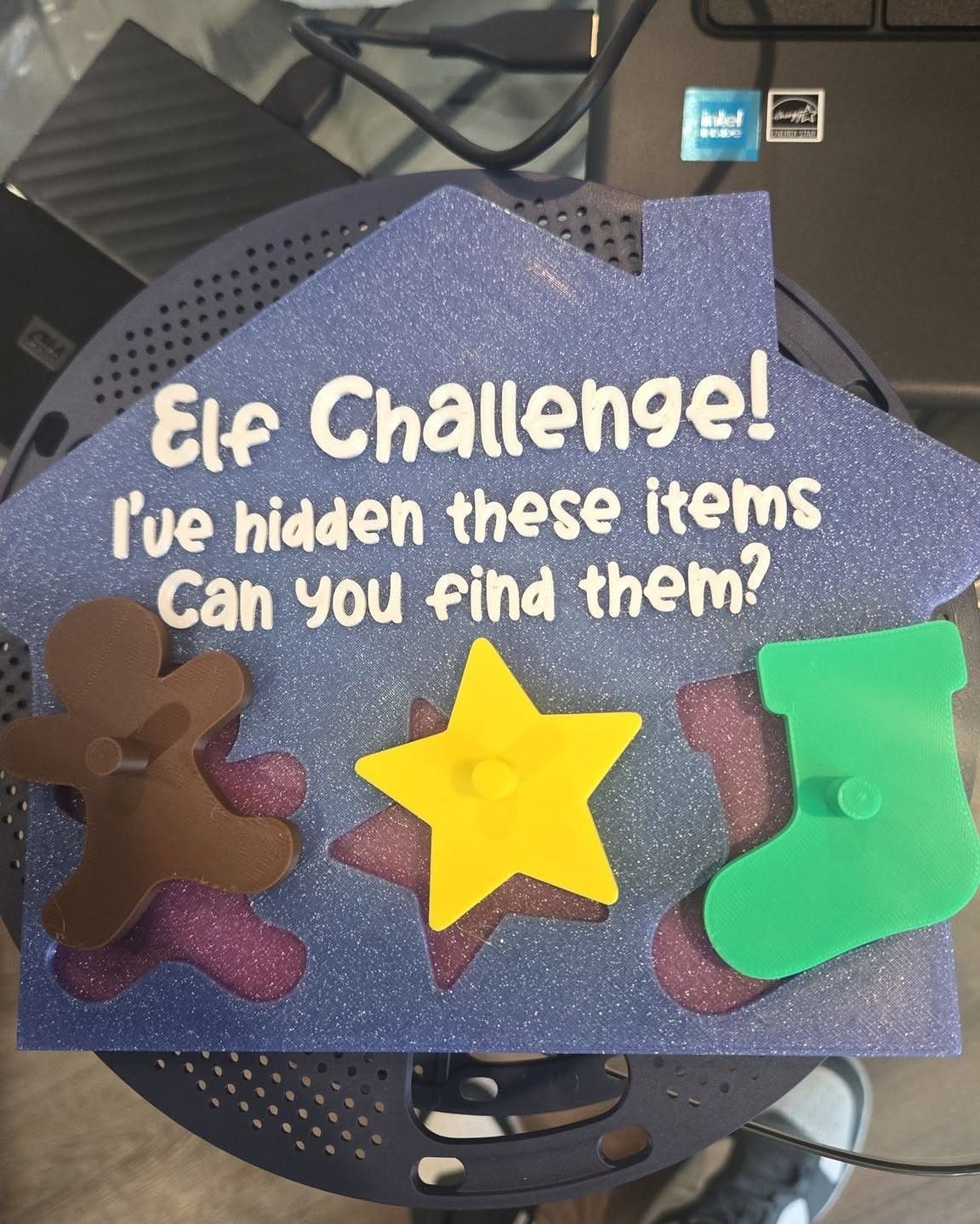 Purple glittery house board for an Elf Challenge scavenger hunt with plastic shapes.