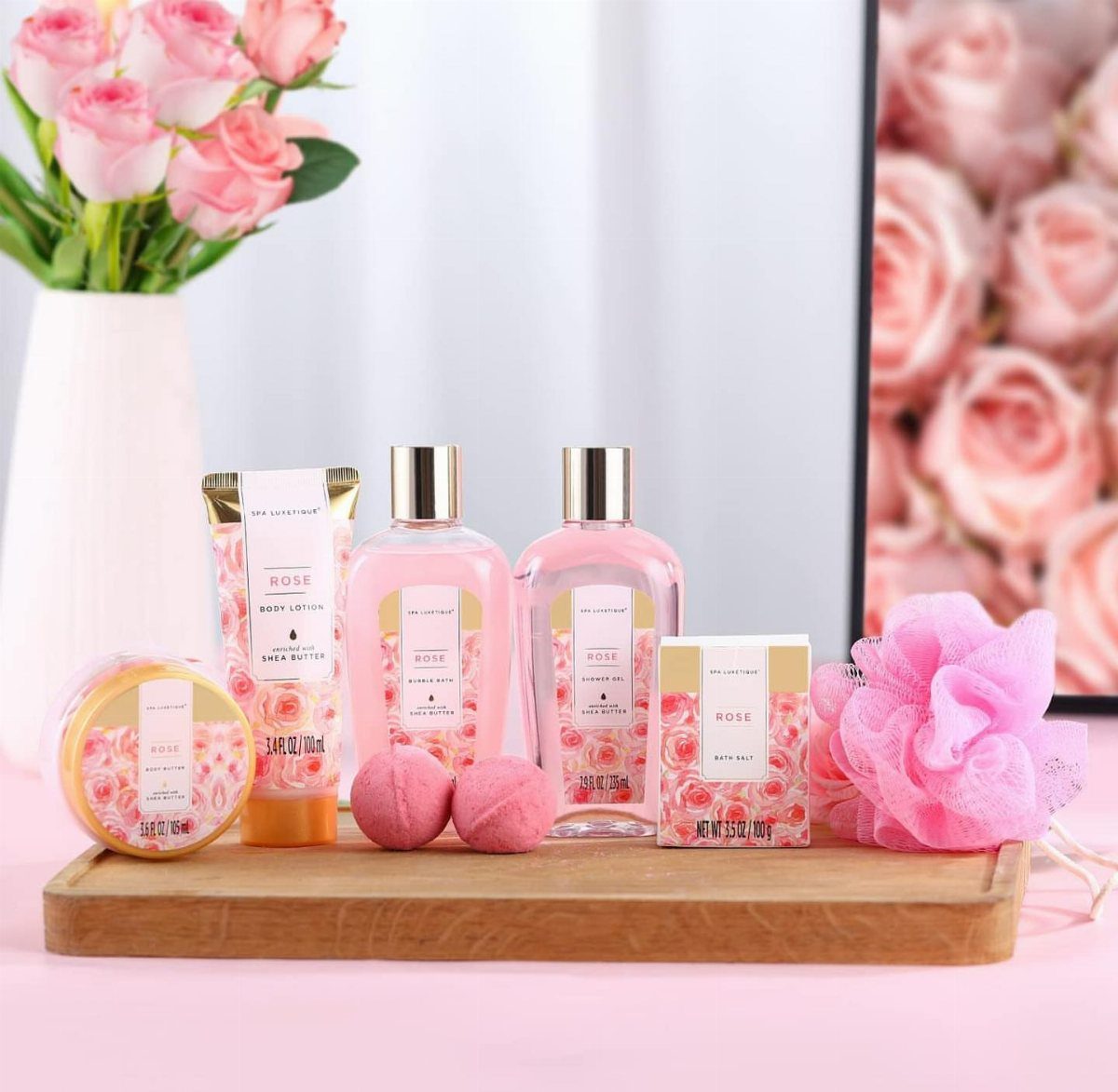 Rose-themed beauty gift set with skincare products and bath accessories on wooden tray