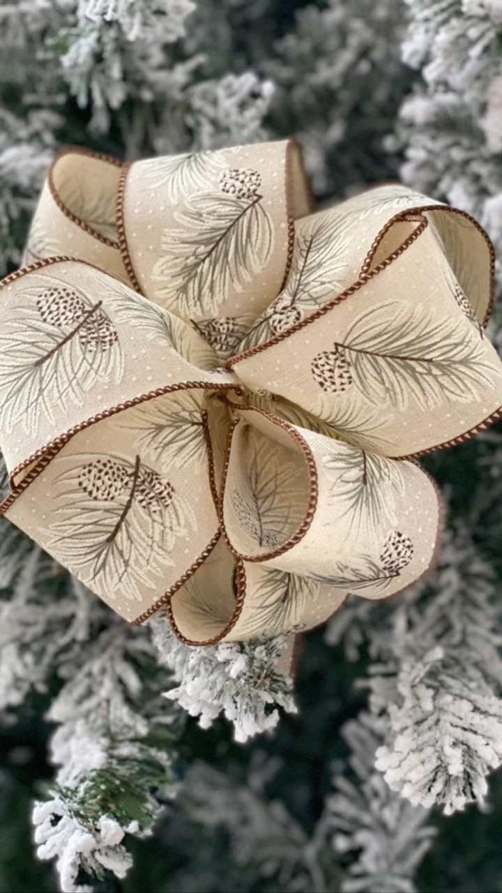 9 Christmas Gift Ribbon Ideas for Pretty Wrapped Presents 2 Large cream ribbon bow with pine prints on a snowy Christmas tree branch
