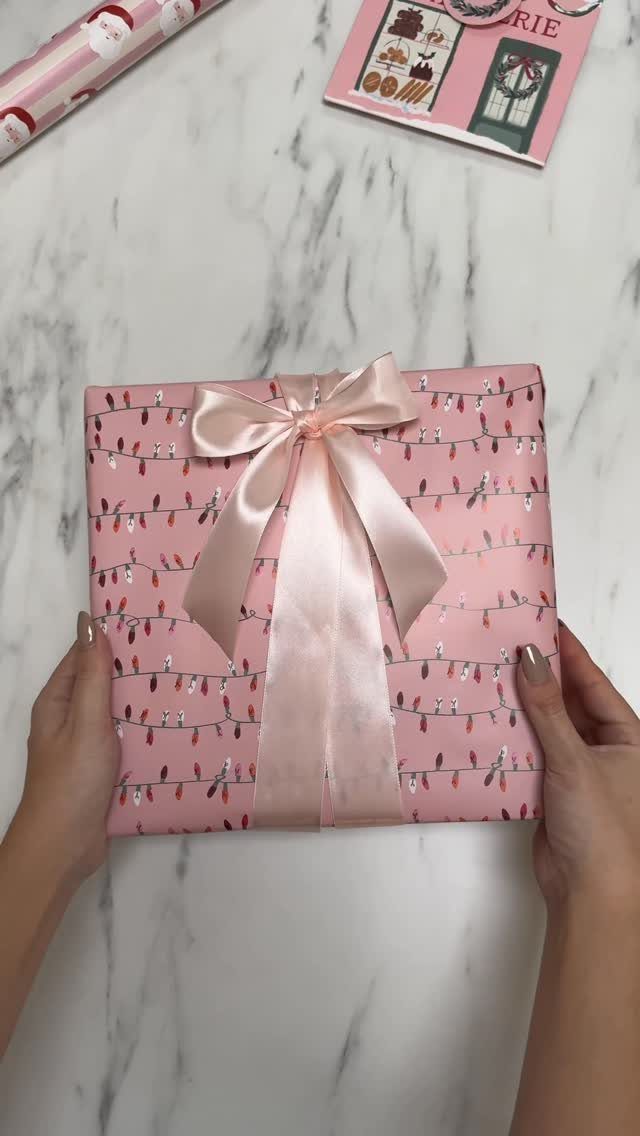9 Christmas Gift Ribbon Ideas for Pretty Wrapped Presents 1 Pink wrapped gift with a pale pink satin bow on marble surface.