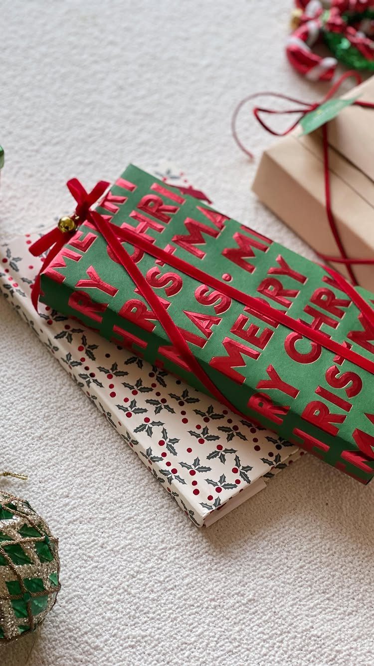 9 Christmas Gift Ribbon Ideas for Pretty Wrapped Presents 8 Green Christmas gift box with red ribbon and gold bell on white paper.