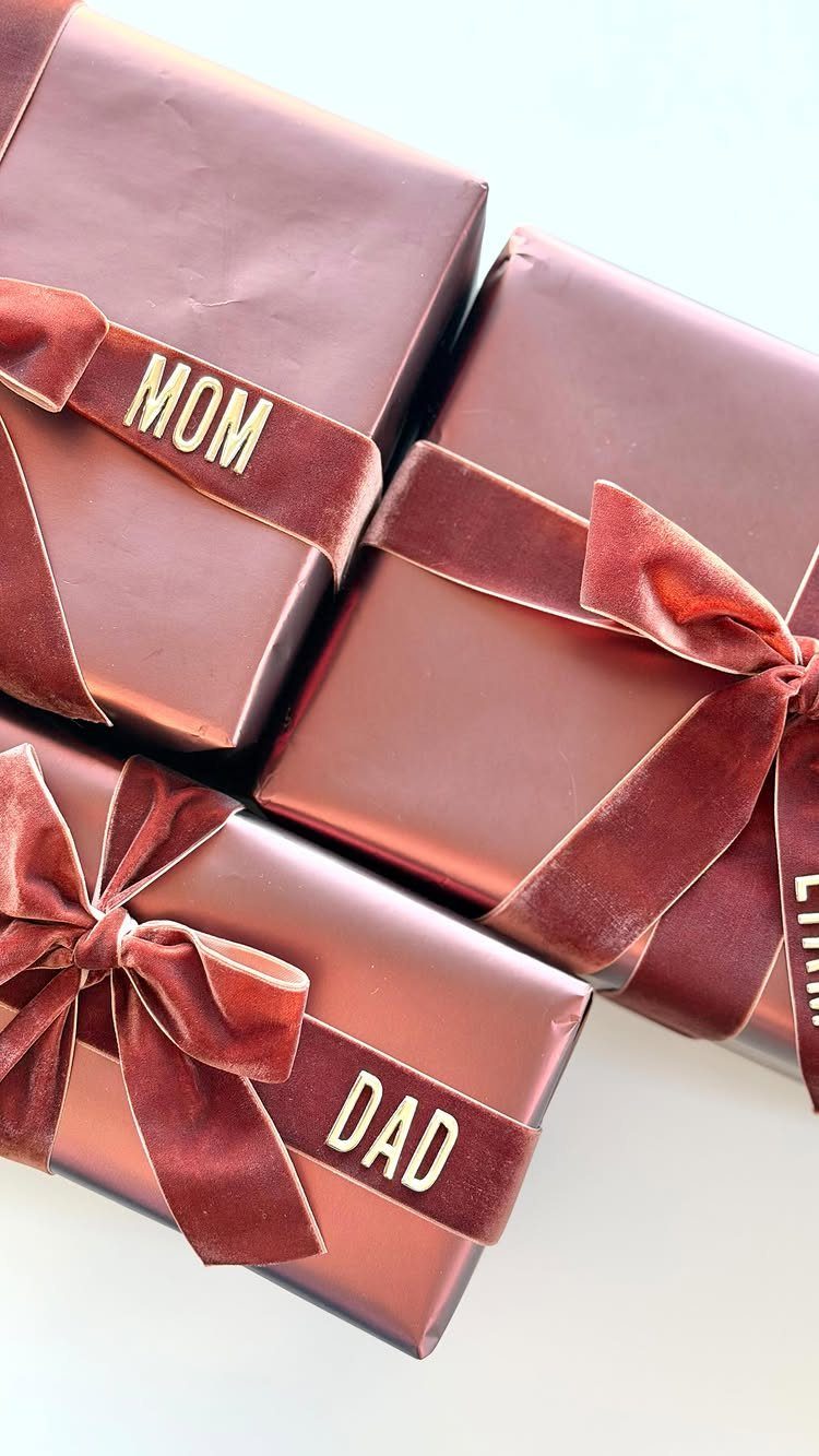 9 Christmas Gift Ribbon Ideas for Pretty Wrapped Presents 7 Rose-gold wrapped gifts tied with deep red velvet ribbons and gold name tags.