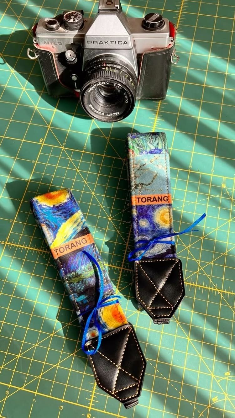 Handmade fabric camera straps with Starry Night print next to a vintage camera.