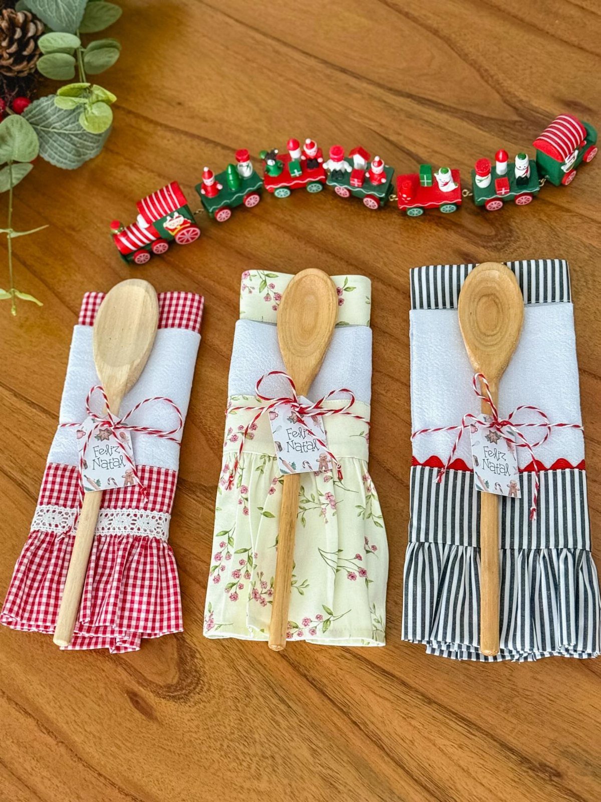 Wooden spoons wrapped in sewn fabric holders with ruffles and festive red twine bows.