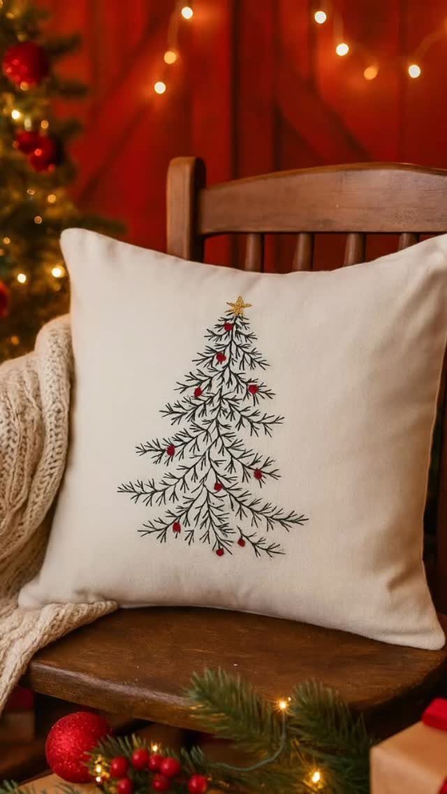 Cream fabric pillow with embroidered Christmas tree resting on a wooden chair