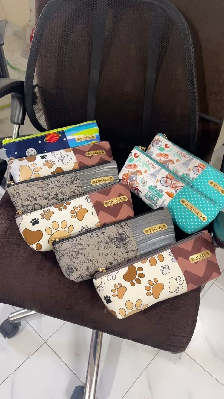 Assorted zippered fabric pencil cases with various patterns resting on a brown chair