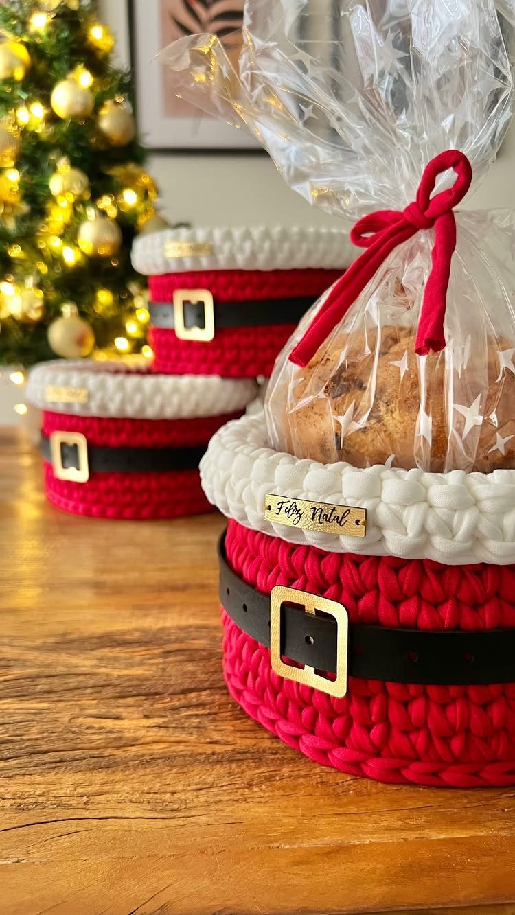 Santa-themed crocheted gift baskets containing baked goods, set against a Christmas tree background.