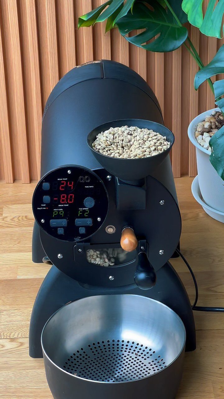 15 Coffee Drinker Gifts: Candles, Mugs, Roasters and More 6 Black home coffee bean roaster with green beans in the hopper and cooling tray.