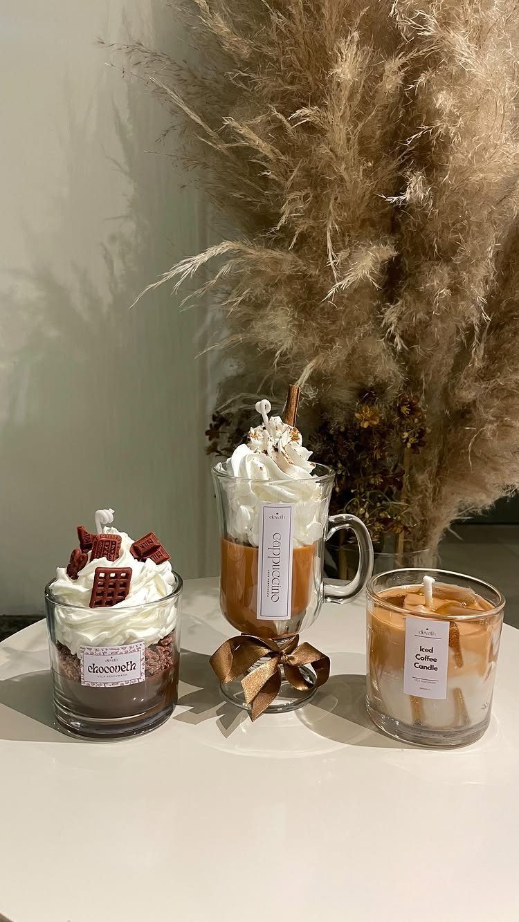 15 Coffee Drinker Gifts: Candles, Mugs, Roasters and More 1 Three coffee-themed candles designed to look like lattes with whipped cream toppings.