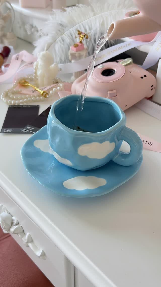 15 Coffee Drinker Gifts: Candles, Mugs, Roasters and More 2 Blue ceramic mug and saucer with white clouds being filled from a teapot