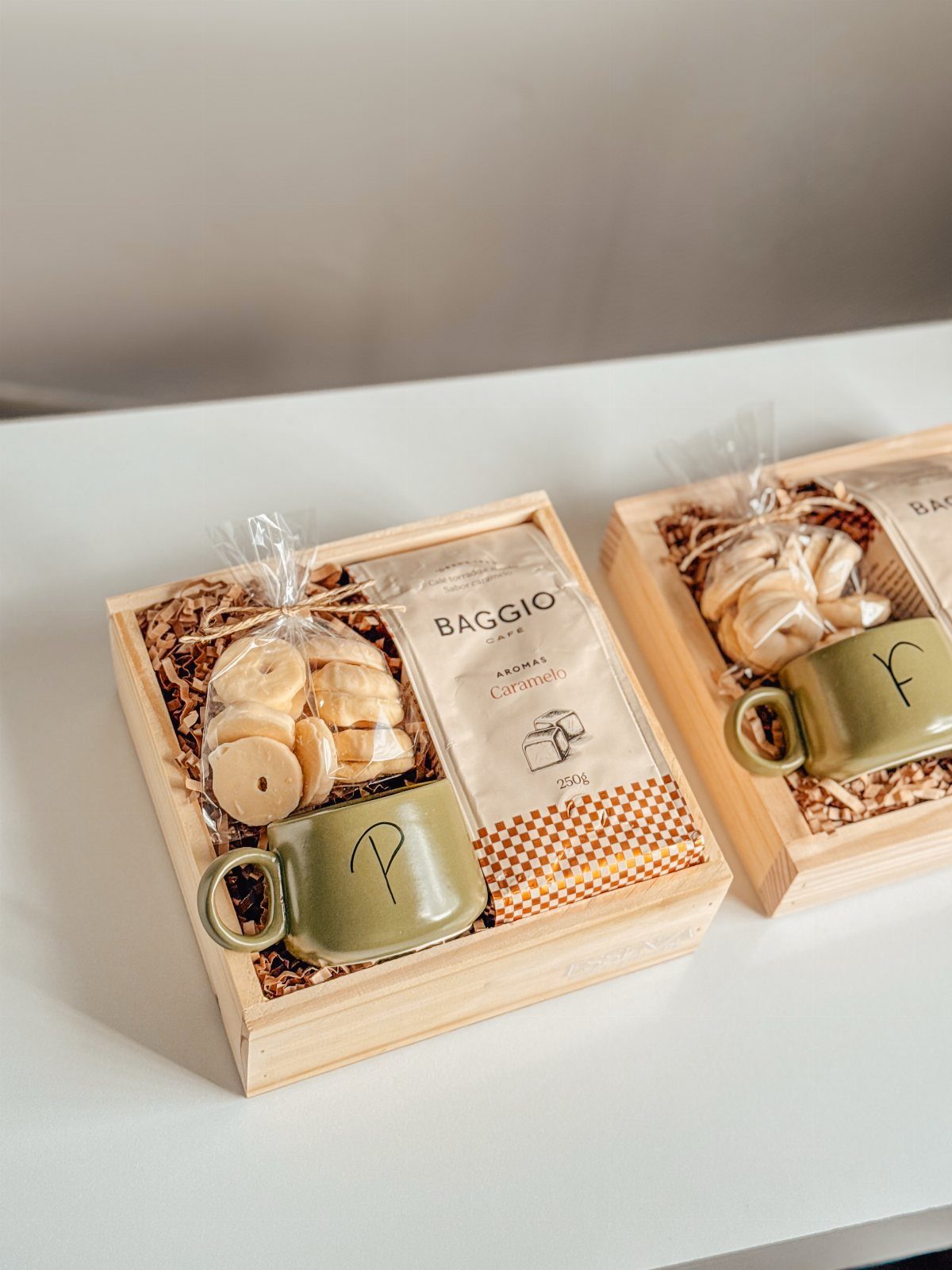 Wooden gift boxes with green coffee mugs, coffee bags, and cookies on filler.