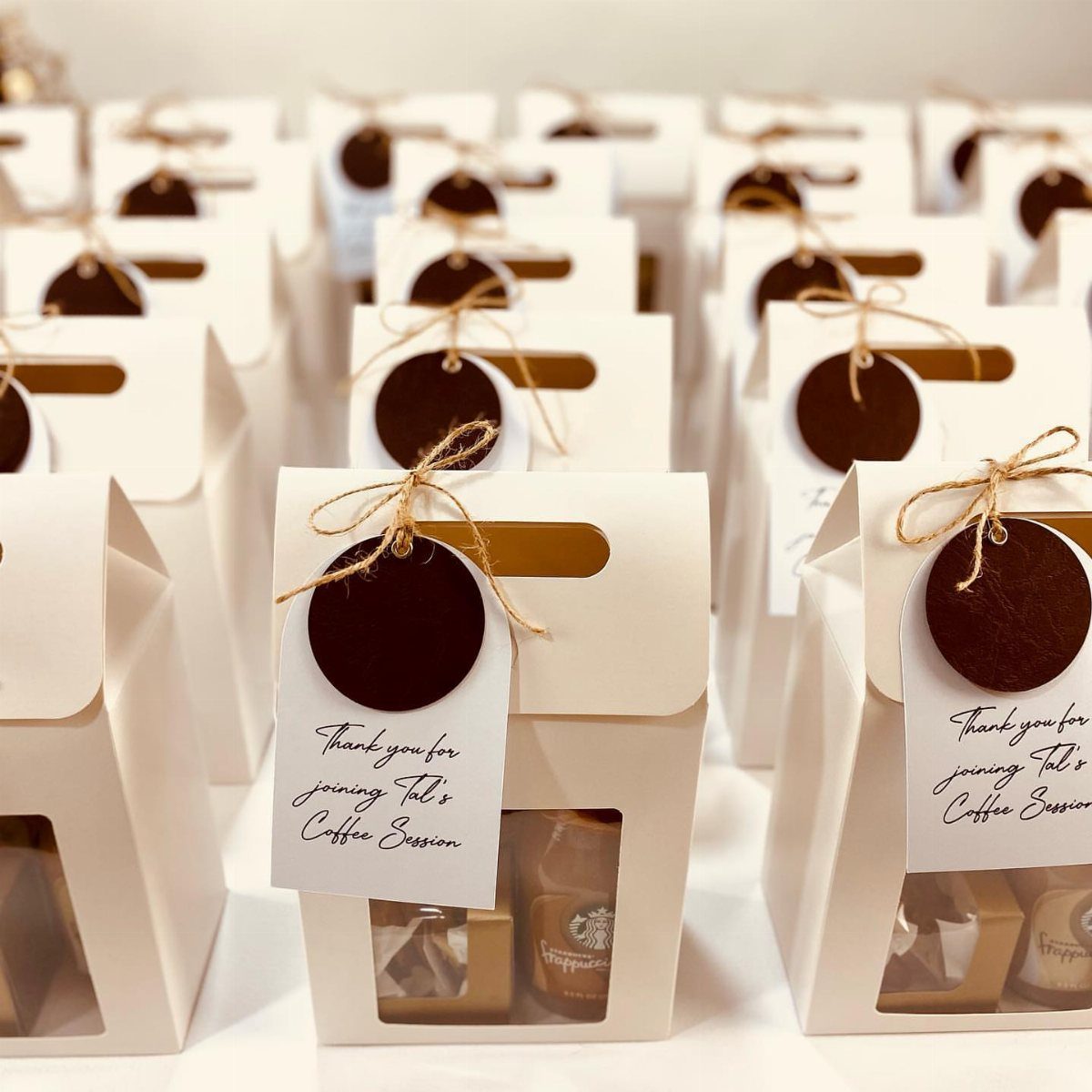 White gift boxes with brown tags containing coffee treats for a coffee session.