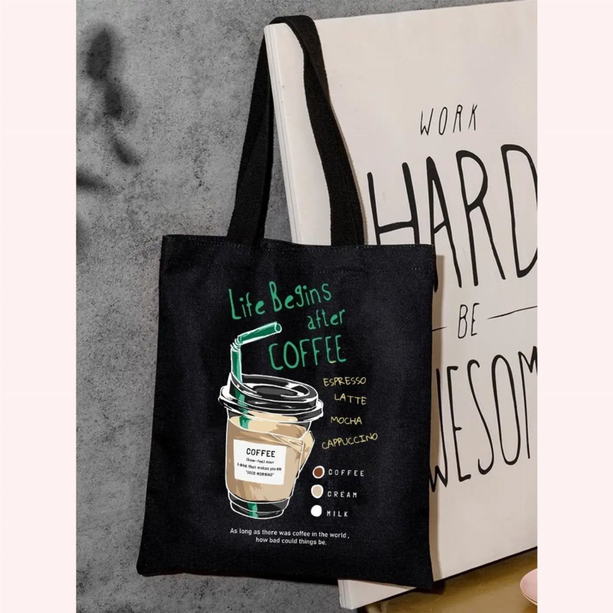 Black canvas tote bag featuring an iced coffee illustration and coffee-themed text.