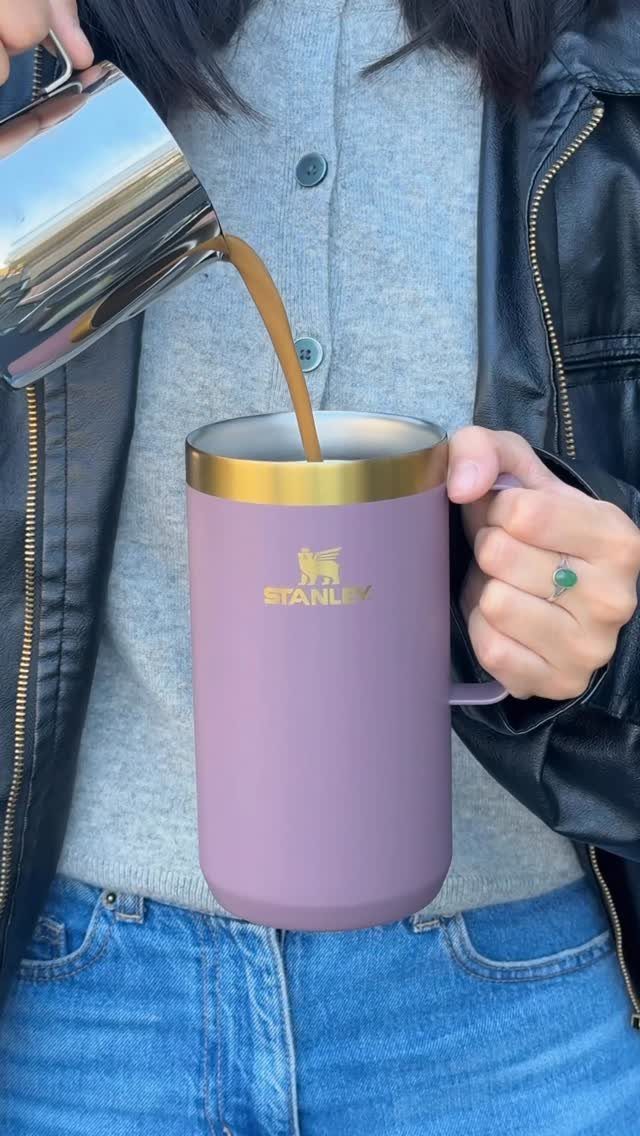 Purple Stanley travel mug being filled with coffee by a person in leather jacket