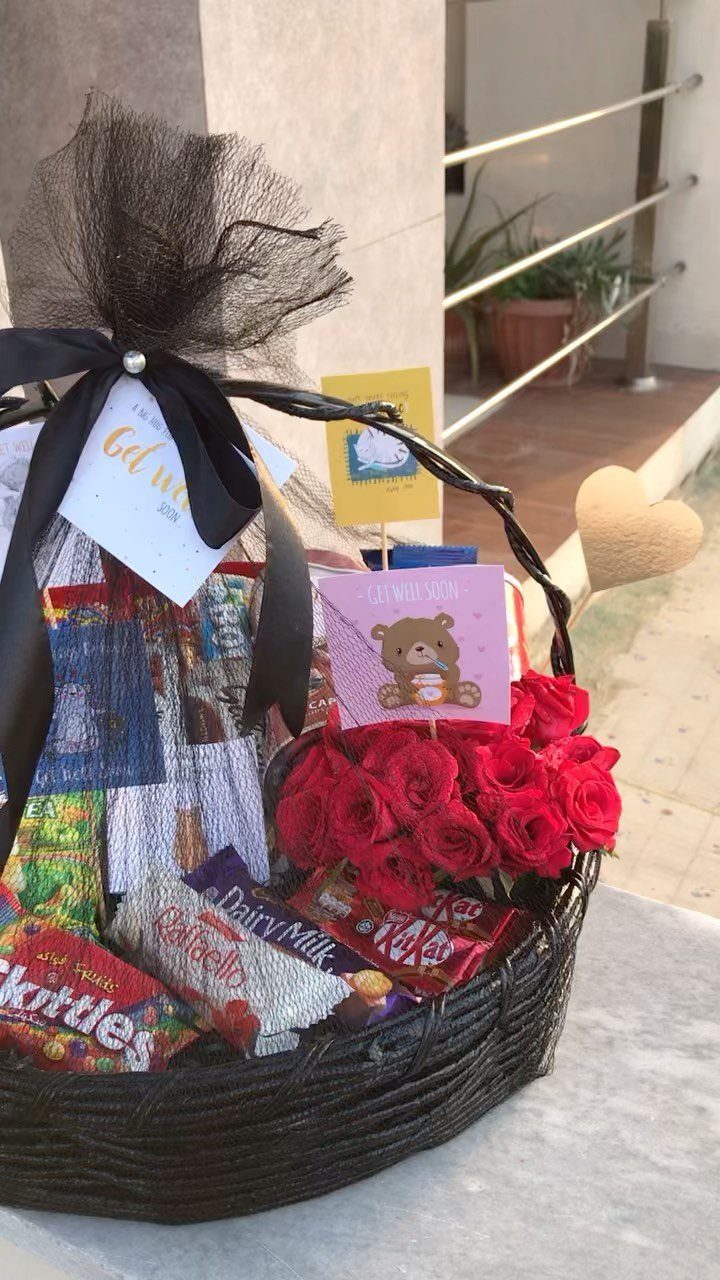 Comfort Gift Basket Ideas for Rough Days: 9 Picks 2 Wicker gift basket filled with chocolates, candies, and red roses wrapped in tulle.