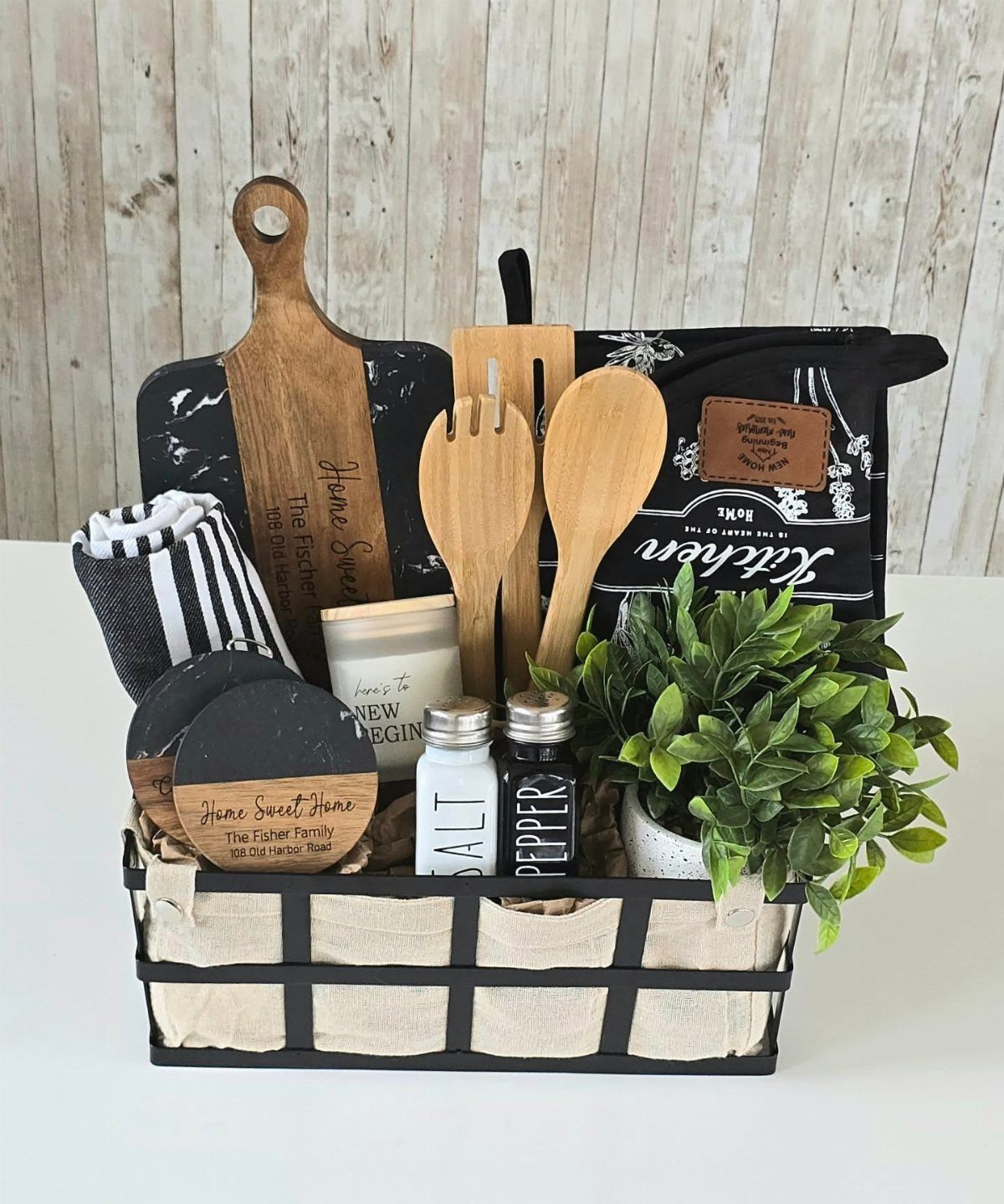Cooking gift basket with wooden utensils, salt and pepper shakers, and a plant.