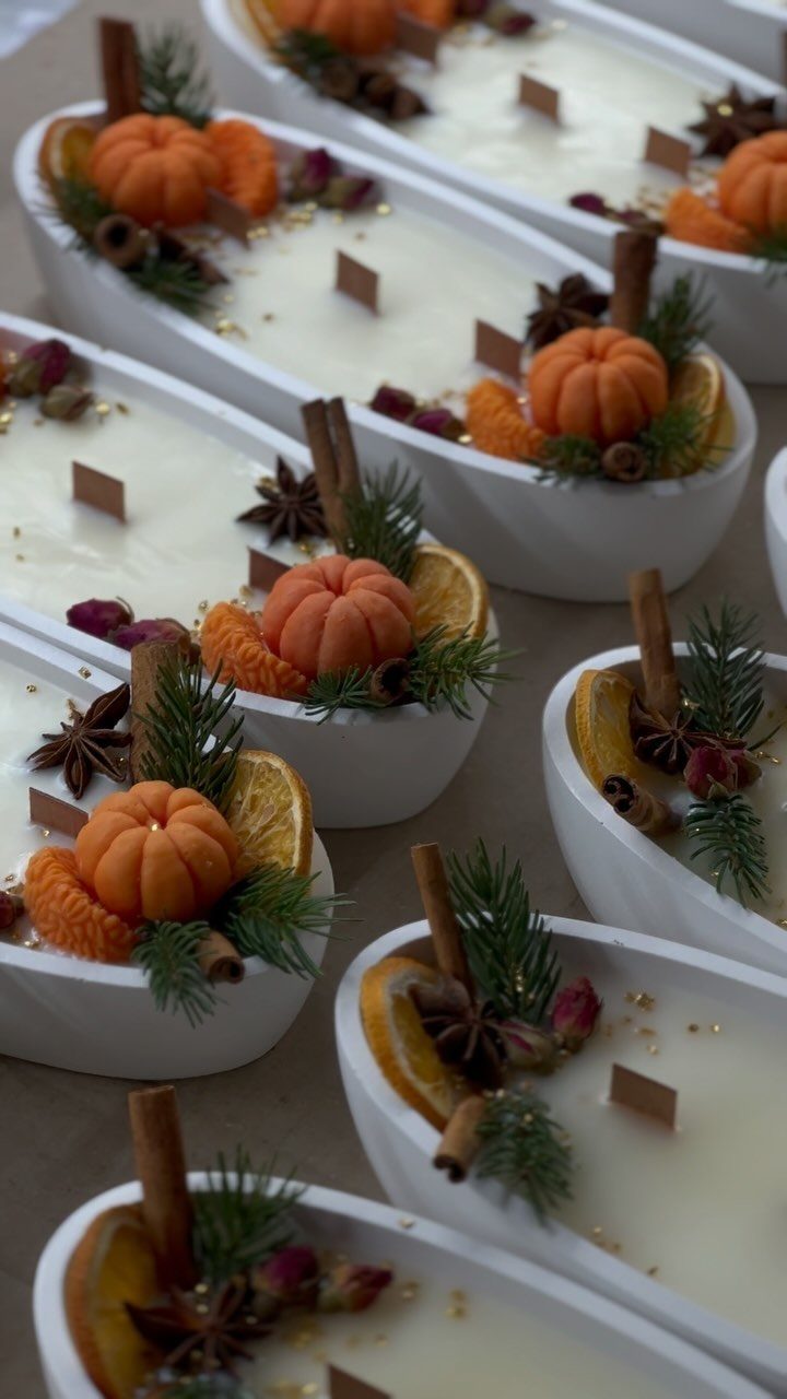 21 Cool Gifts for Adults: Practical Picks for 2026 2 White wax candles in oval bowls decorated with pumpkins, cinnamon, and pine needles.