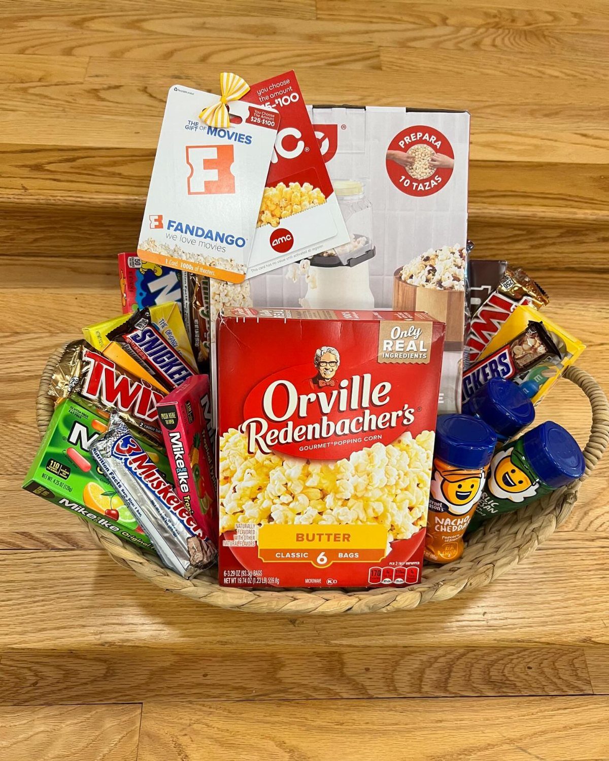 Movie night gift basket with popcorn, assorted candies, and a movie ticket voucher.