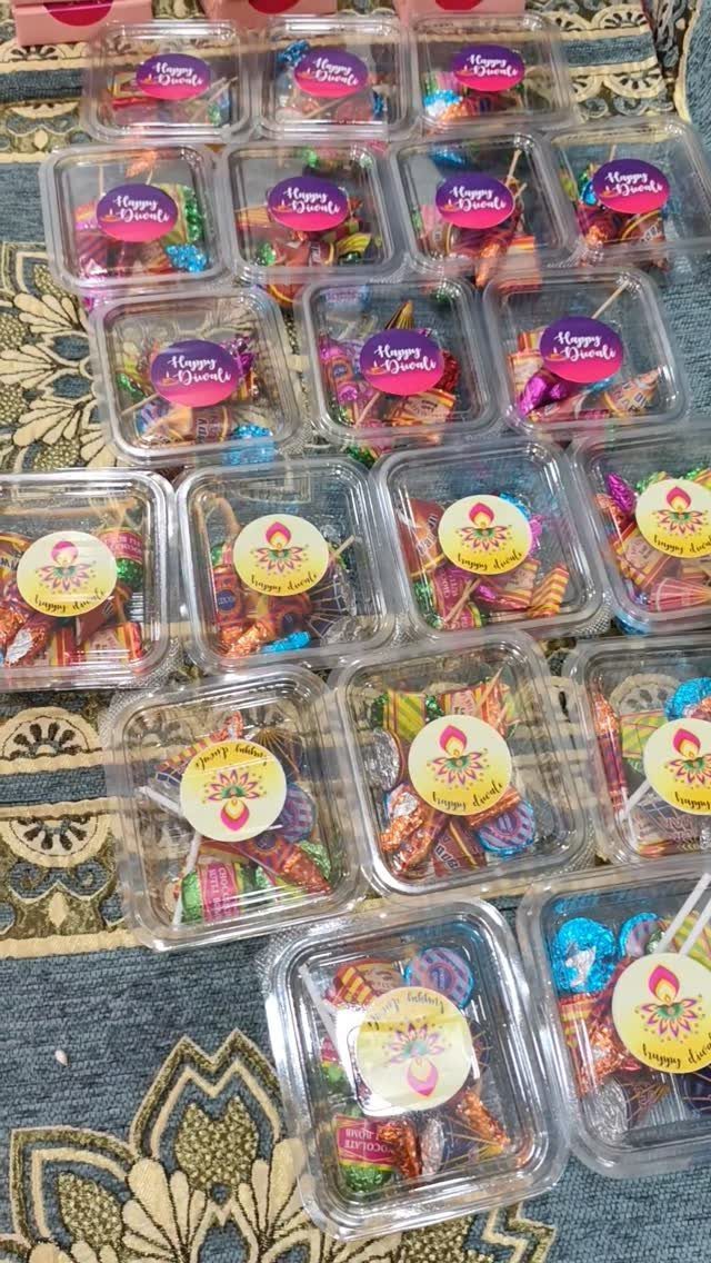 Diwali Gift Hampers: 8 Ideas for Sweets, Dry Fruit & More 3 Small clear plastic boxes filled with colorful chocolates and candies for Diwali gifts.
