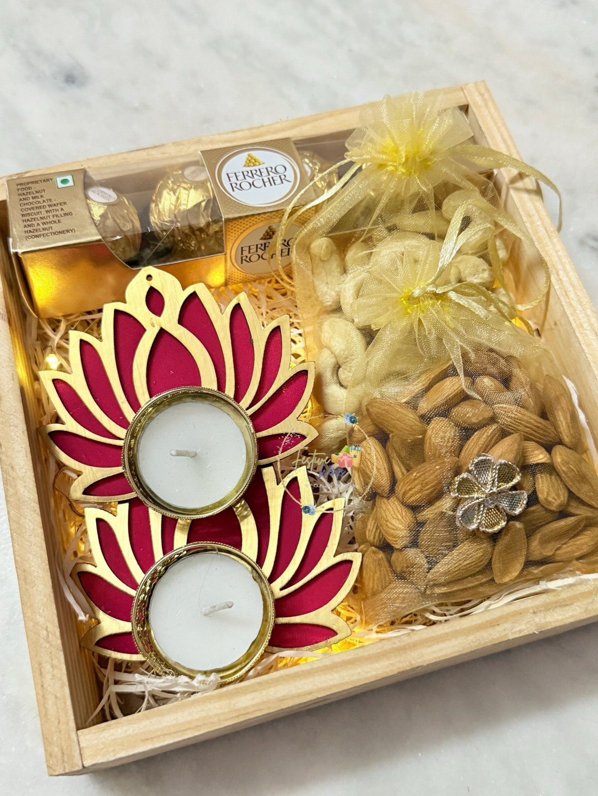 Diwali Gift Hampers: 8 Ideas for Sweets, Dry Fruit & More 1 Wooden Diwali gift hamper with lotus tea lights, chocolates, and pouches of nuts.