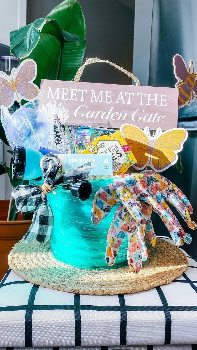 Gardening gift basket in a turquoise pot with floral gloves and seed packets.