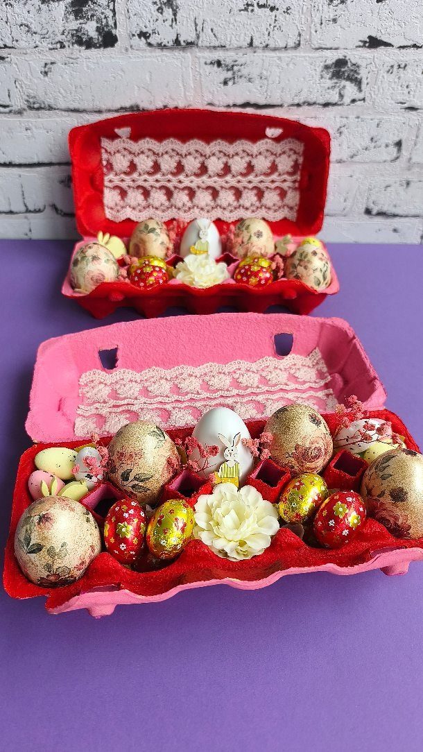 Decorated Easter eggs in red and pink cartons with lace and floral accents.
