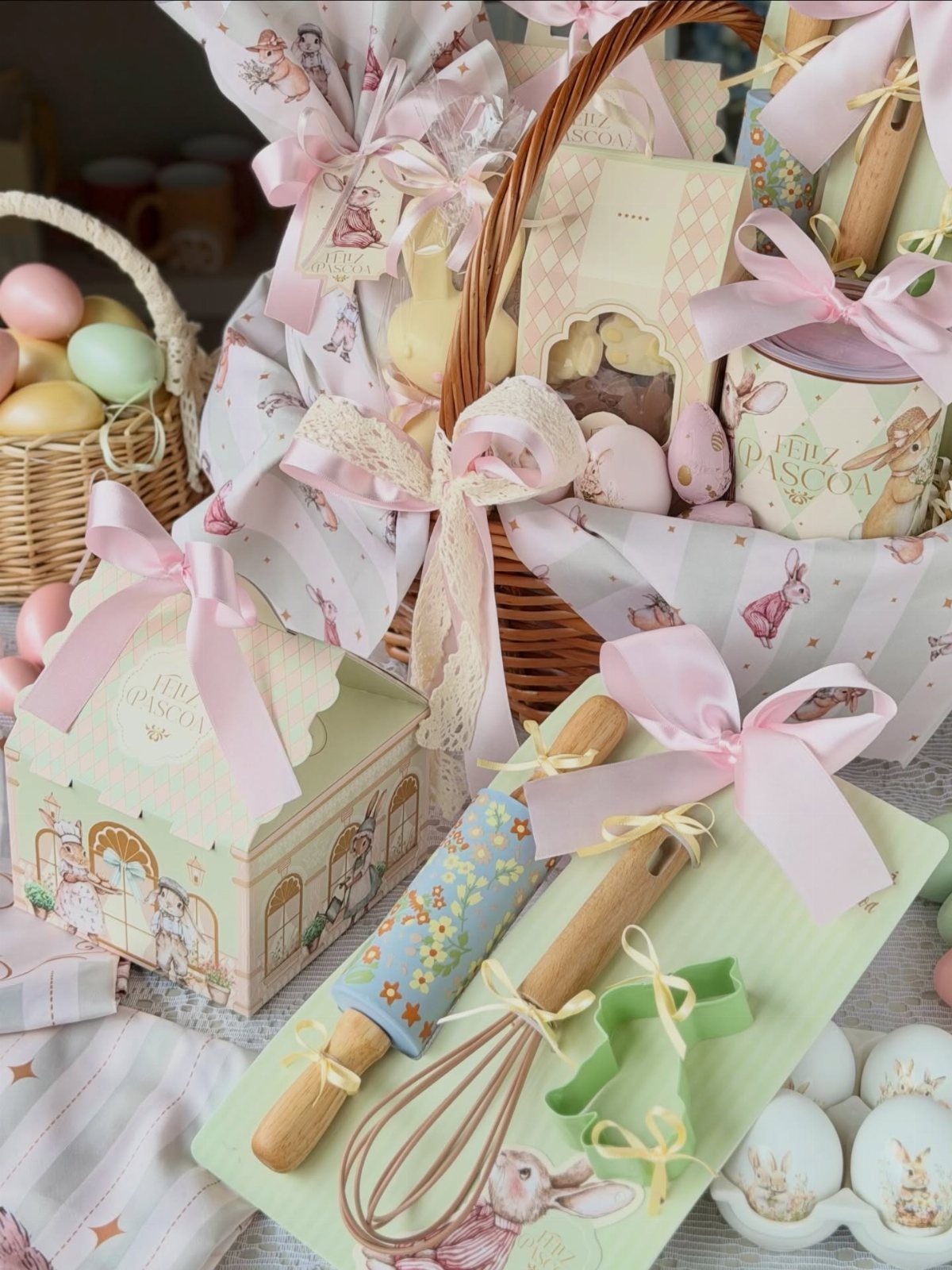 Easter gift set with a wicker basket, baking tools, and pastel decorated eggs.
