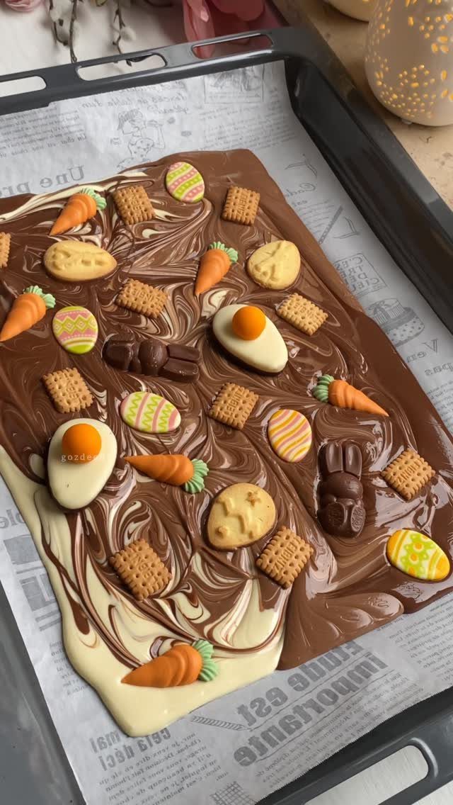 Chocolate bark with Easter eggs, carrots, and bunnies on a baking tray