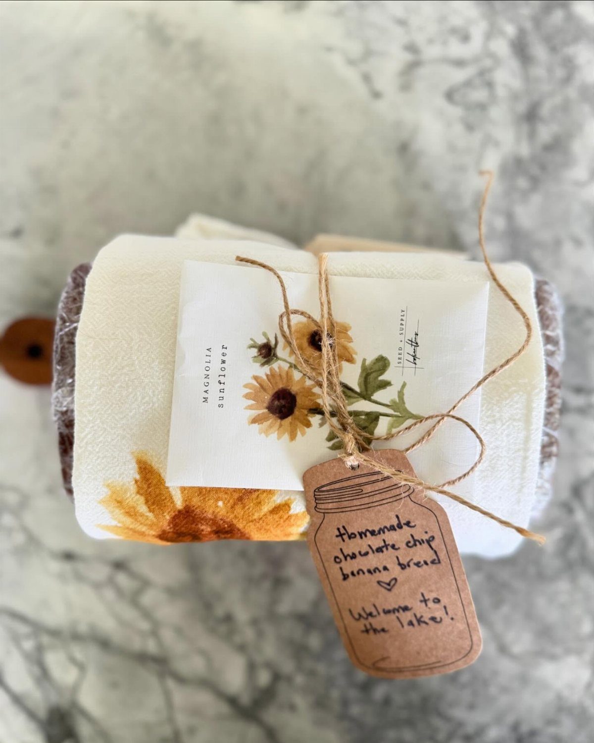 13 Easy Gifts for Neighbors You Can Make or Bake 11 Wrapped loaf of banana bread with sunflower fabric and a welcome gift tag.