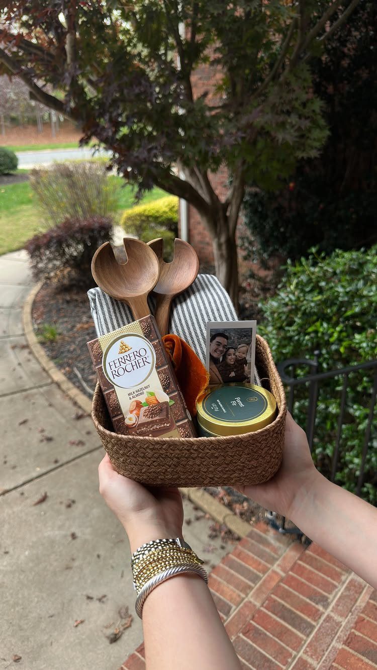 13 Easy Gifts for Neighbors You Can Make or Bake 12 Woven gift basket with chocolates, wooden servers, and a photo held by hands.