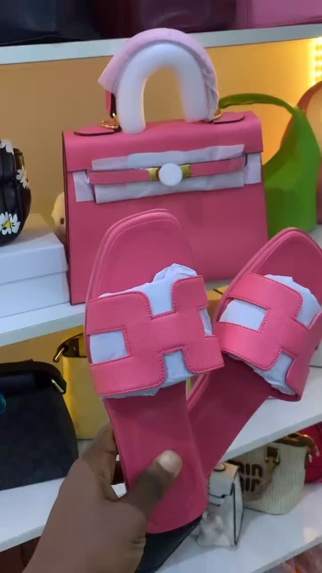 Pink slide sandals and a matching pink handbag displayed on white retail shelves.