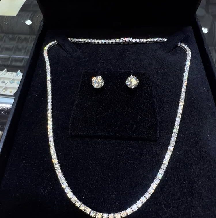 Silver tennis necklace and stud earrings set in a black velvet jewelry box