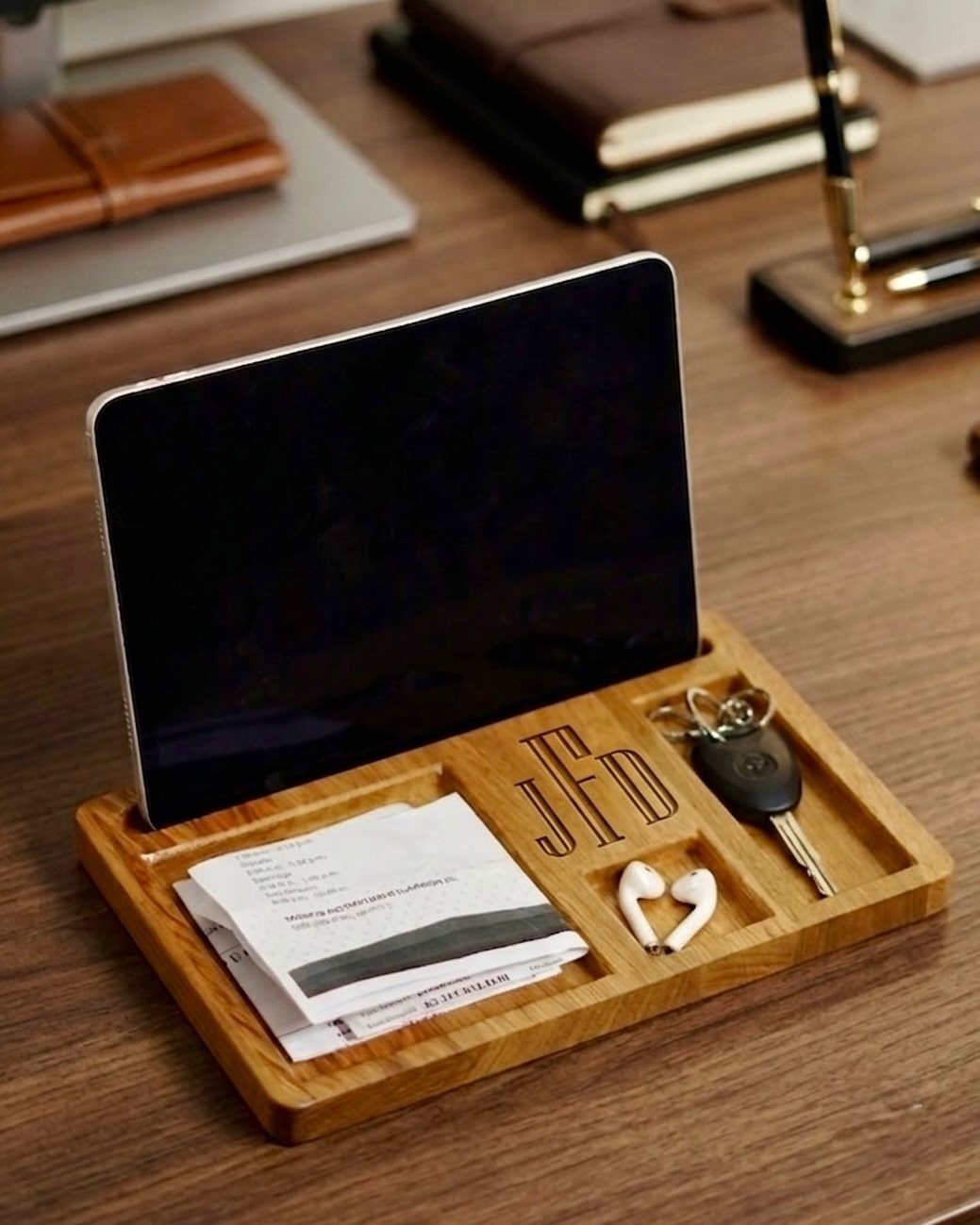 7 Father in Law Gift Ideas He'll Actually Use 4 Wooden valet tray with engraved initials holding a phone, keys, and wireless earbuds.