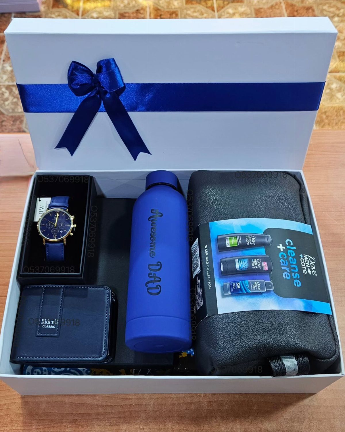 8 Fathers Day Gift Basket Ideas for Every Kind of Dad 3 Gift box for dad containing a blue watch, wallet, water bottle, and grooming kit.