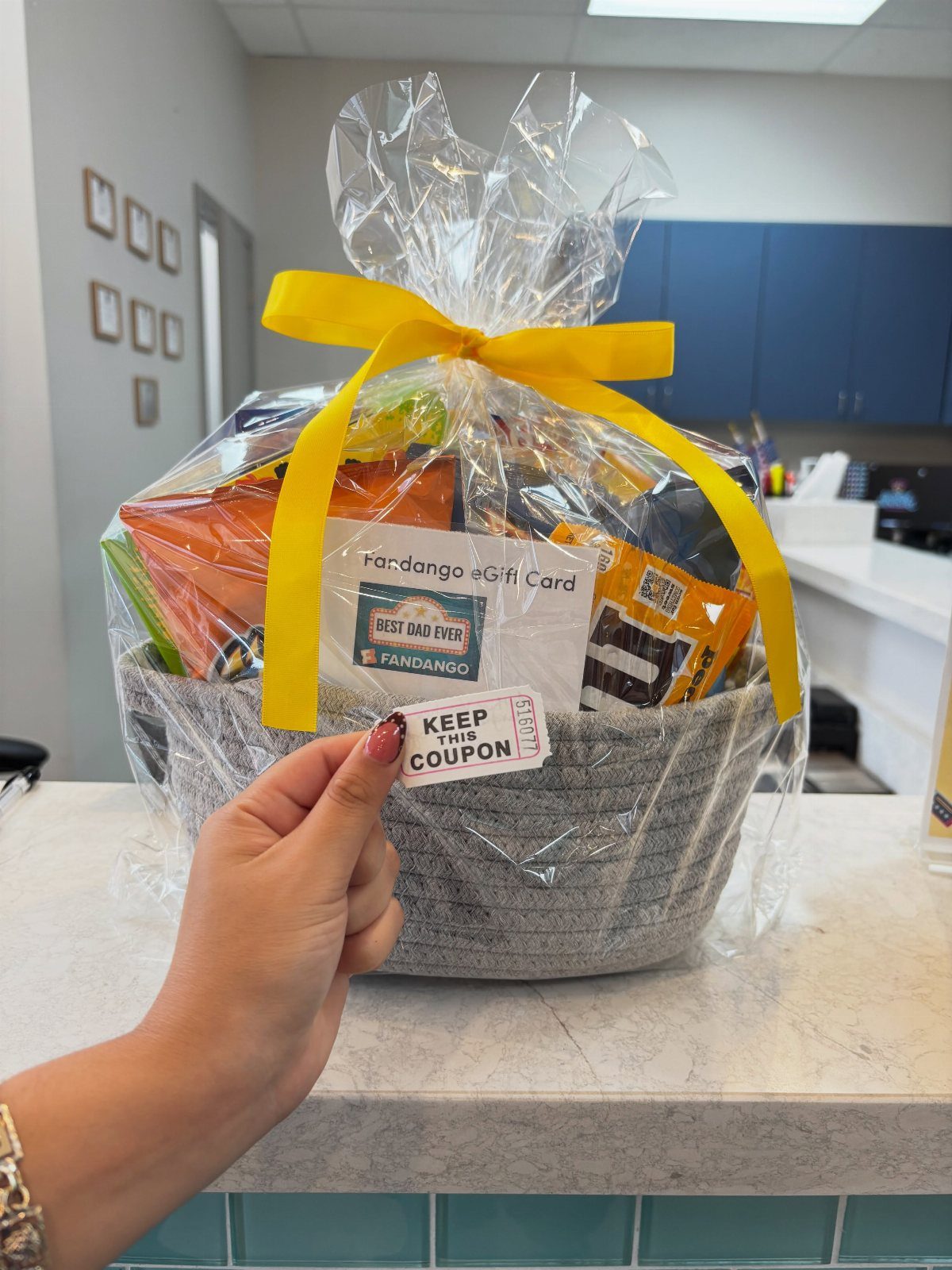 8 Fathers Day Gift Basket Ideas for Every Kind of Dad 2 Movie night snack basket with snacks and a Fandango gift card wrapped in cellophane.