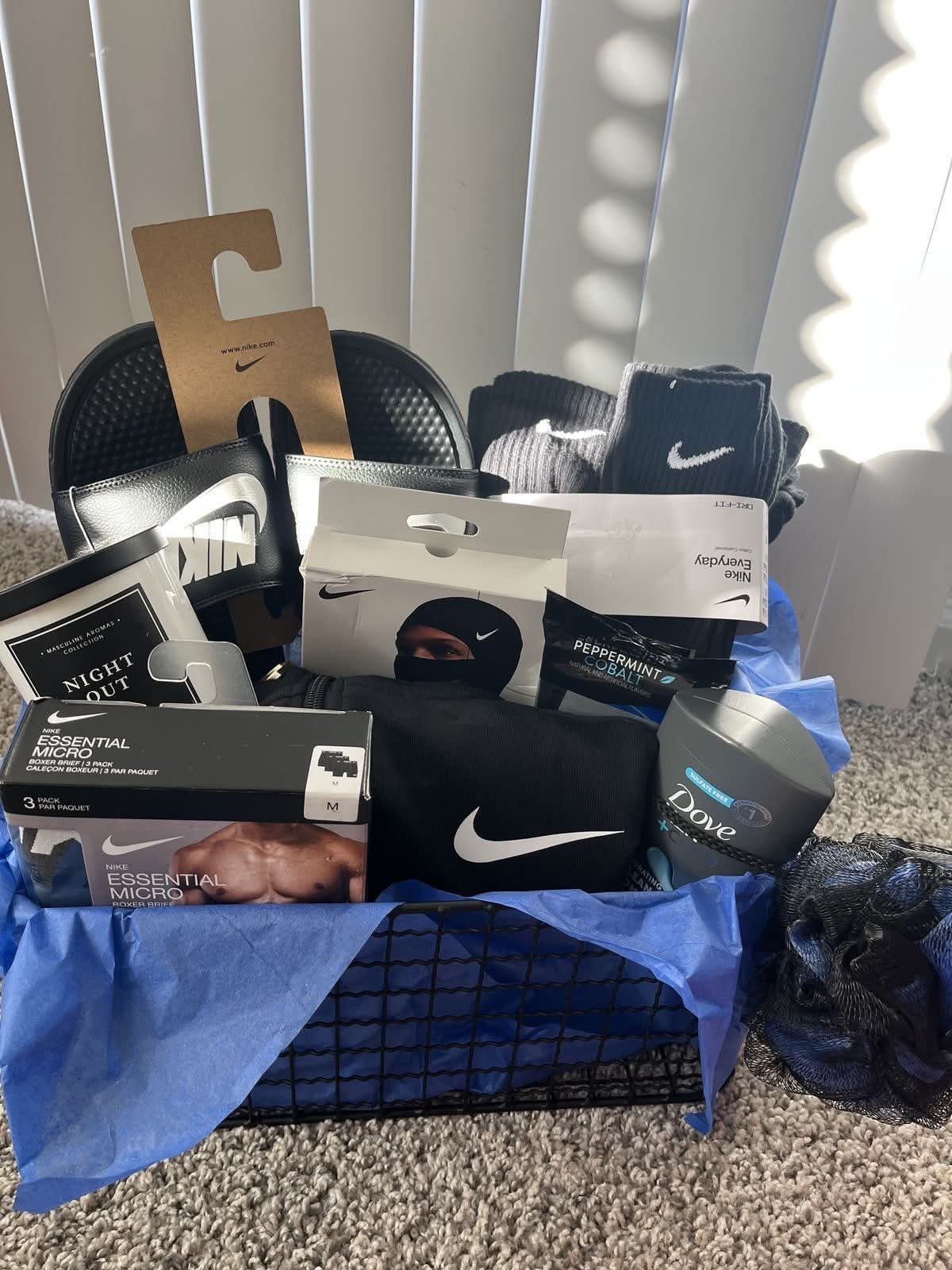 8 Fathers Day Gift Basket Ideas for Every Kind of Dad 8 Nike branded gift basket with black slides, socks, and grooming products in blue tissue