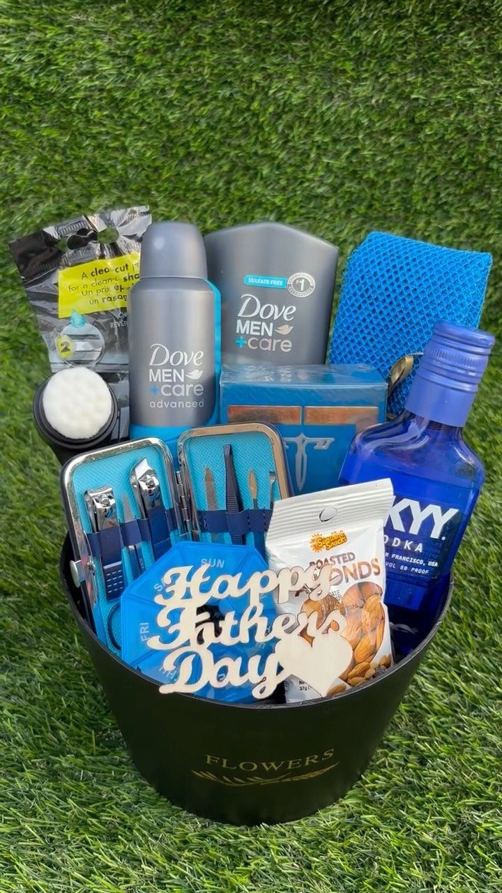 Gift basket with grooming products, vodka, and snacks for Father's Day on grass.