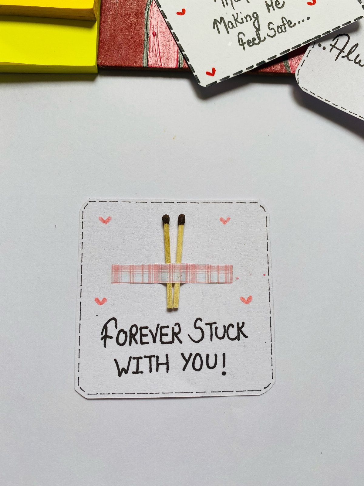 Two matches taped together on a card reading Forever Stuck With You