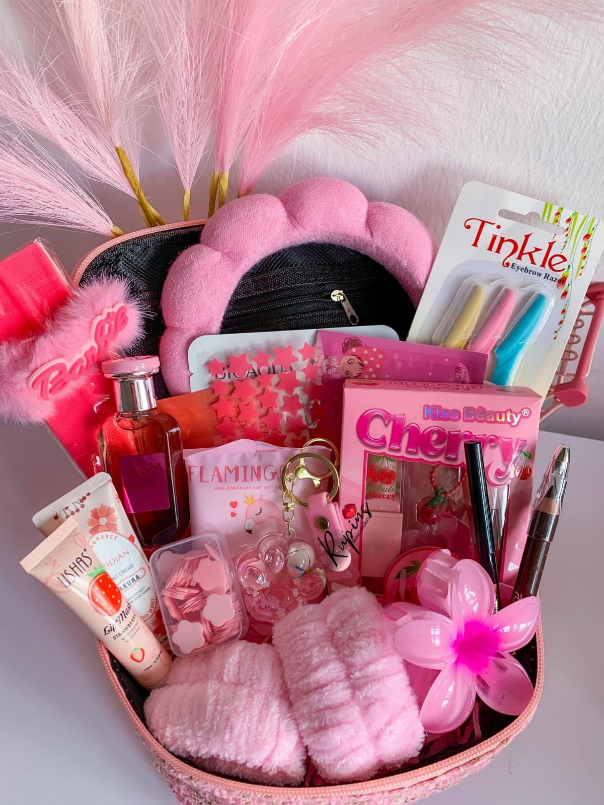 Pink self-care gift basket filled with beauty products, plush headband, and skincare items.