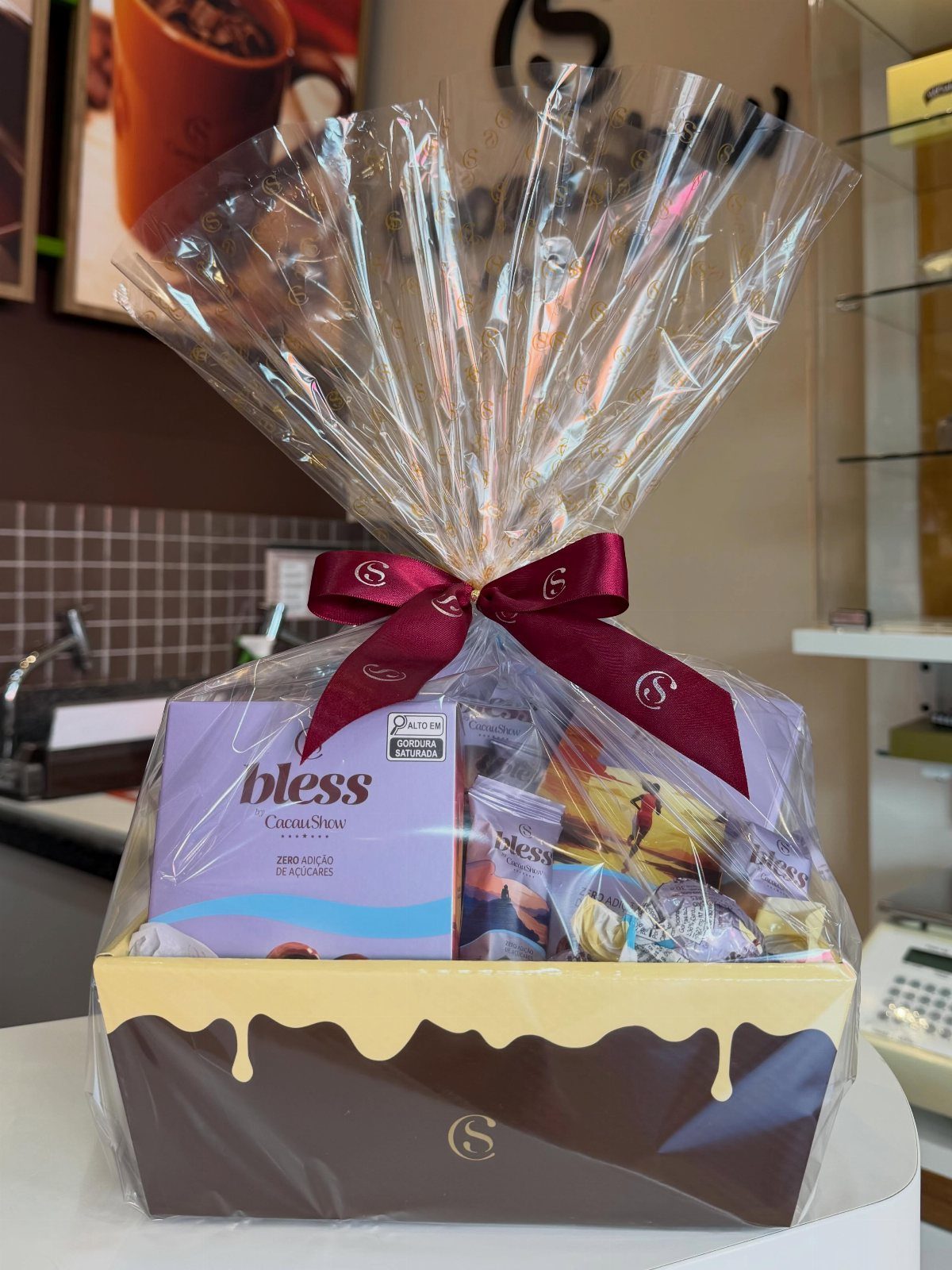 Gift basket wrapped in cellophane containing sugar-free chocolates and assorted snacks.
