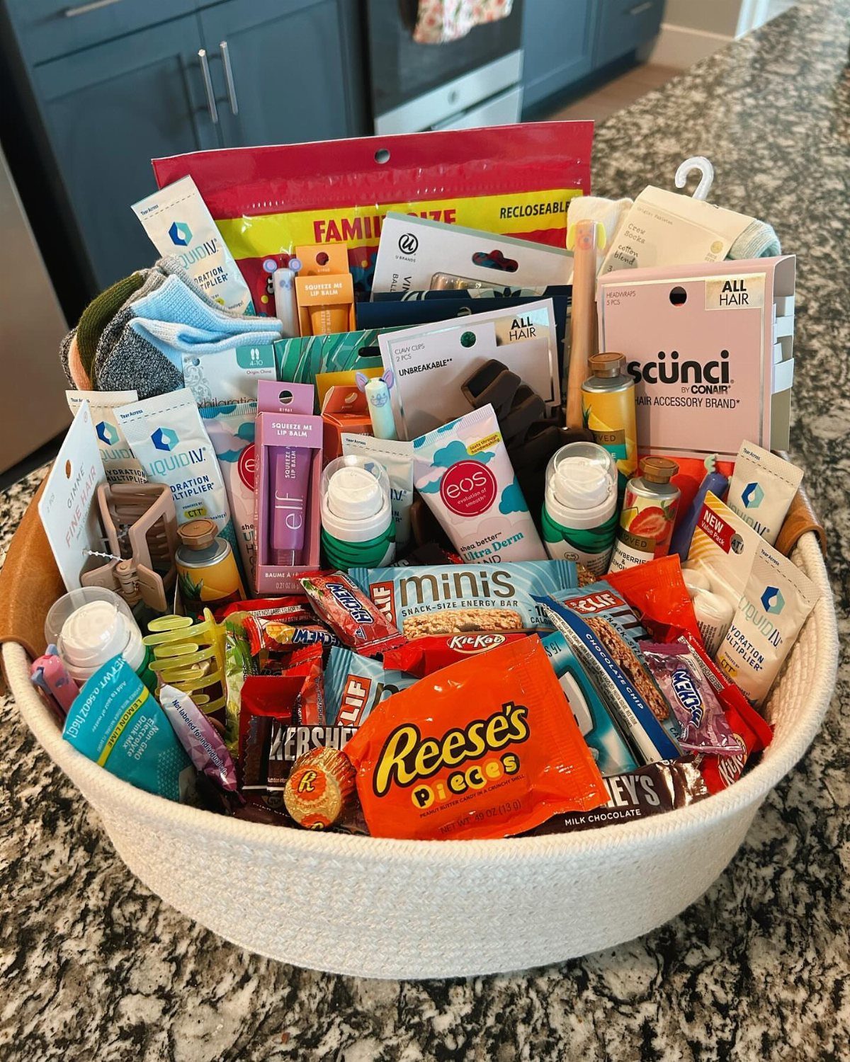White woven gift basket filled with assorted candies, snacks, and personal care items.