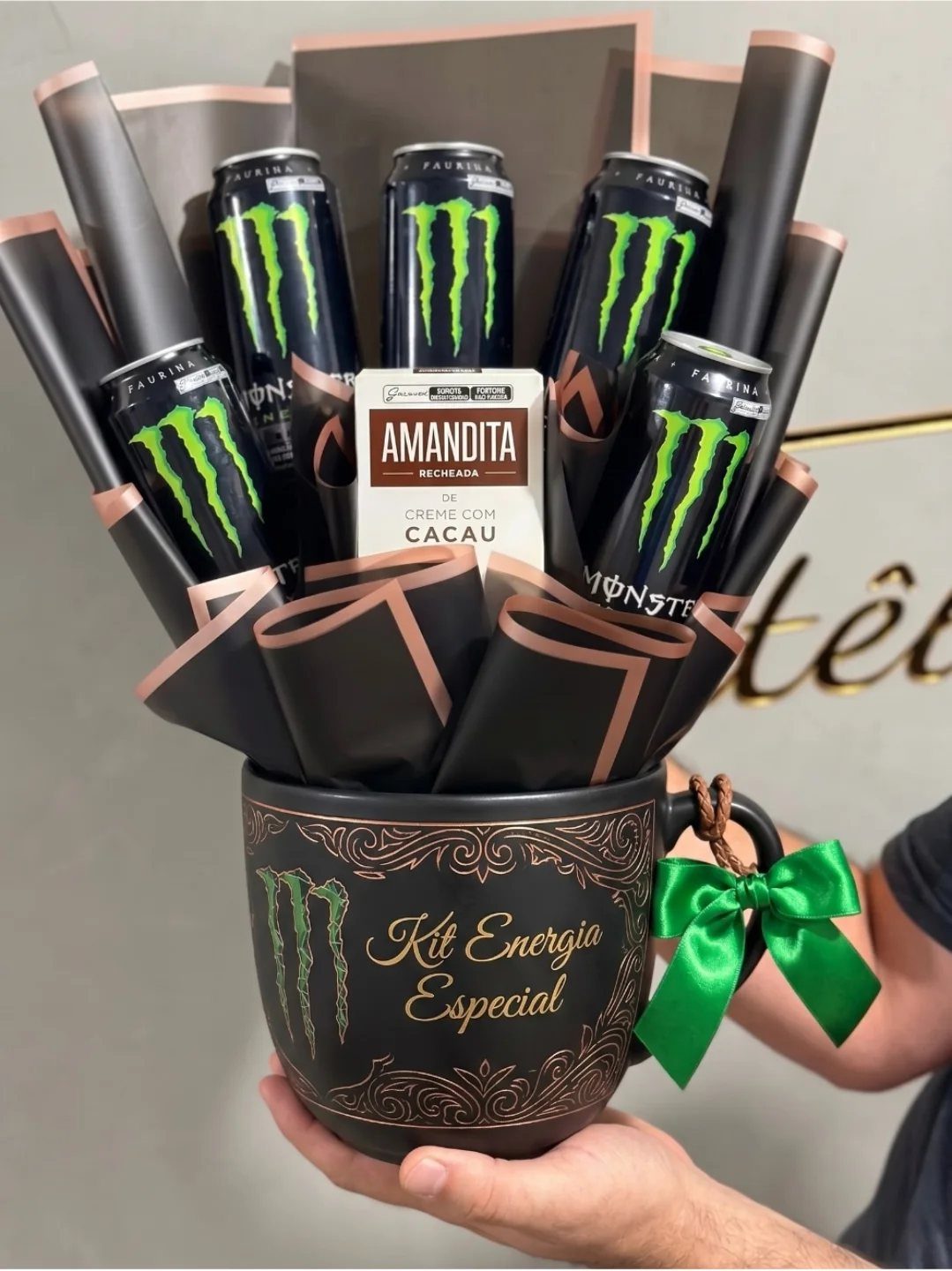 Energy drink cans and chocolate arranged as a bouquet in a black mug.