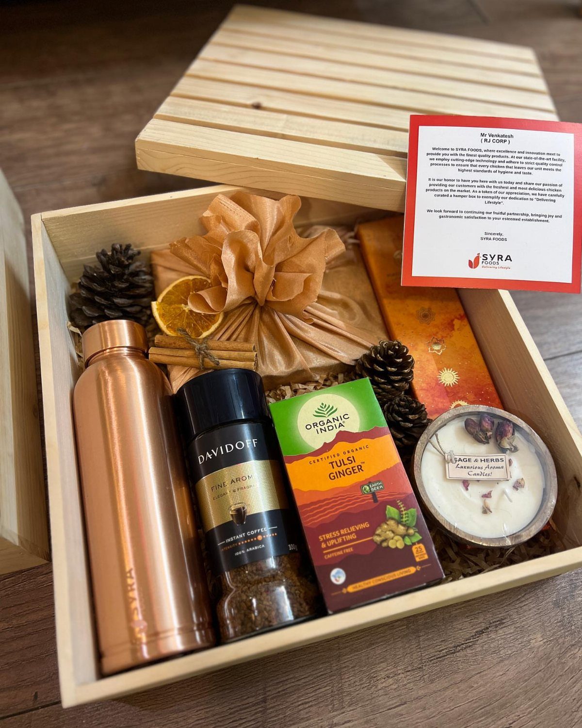 Gift Basket Ideas for Staff: 8 Picks From Wine to Coffee 8 Wooden gift box with copper bottle, coffee, tea, candle, and wrapped present.