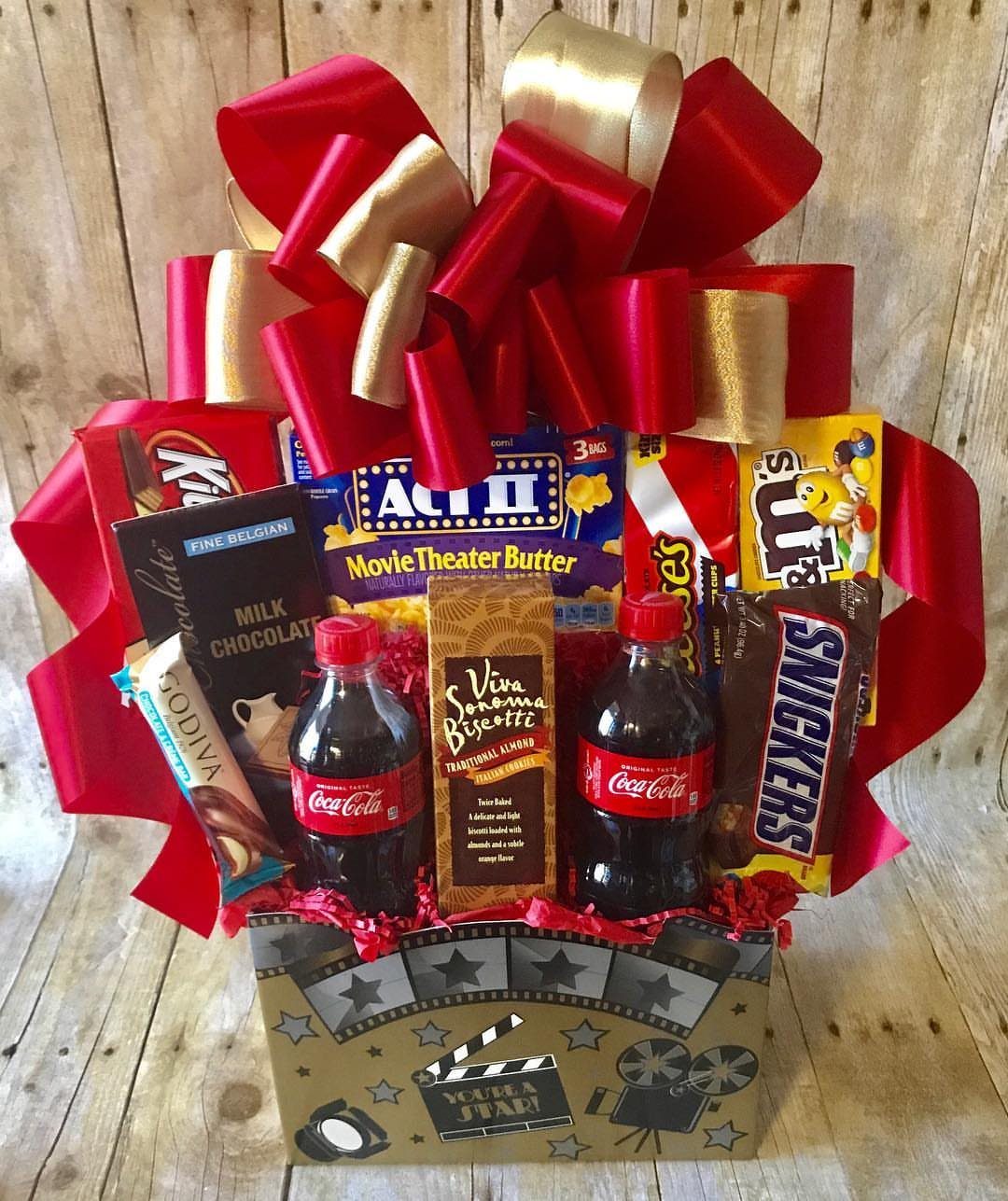 Gift Basket Ideas for Staff: 8 Picks From Wine to Coffee 5 Movie night gift basket with popcorn, soda, and candy topped with a red bow.