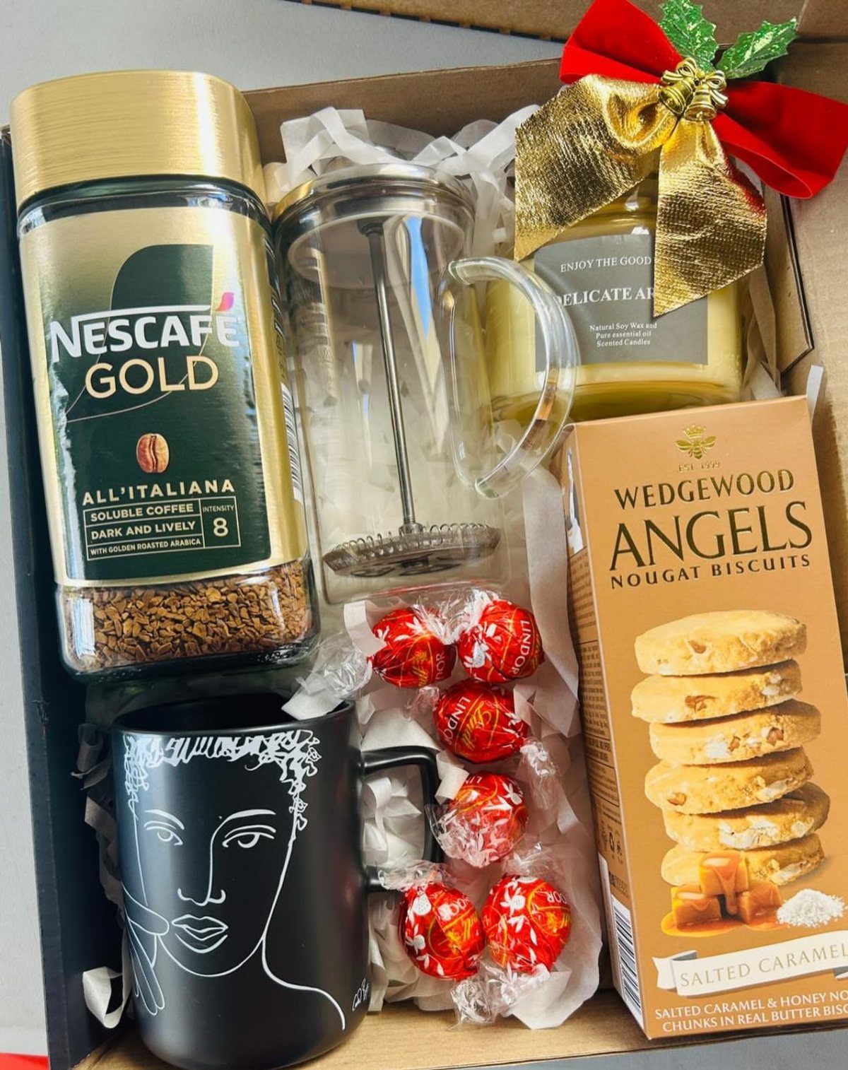 Coffee gift basket with Nescafe Gold, French press, black mug, and biscuits.
